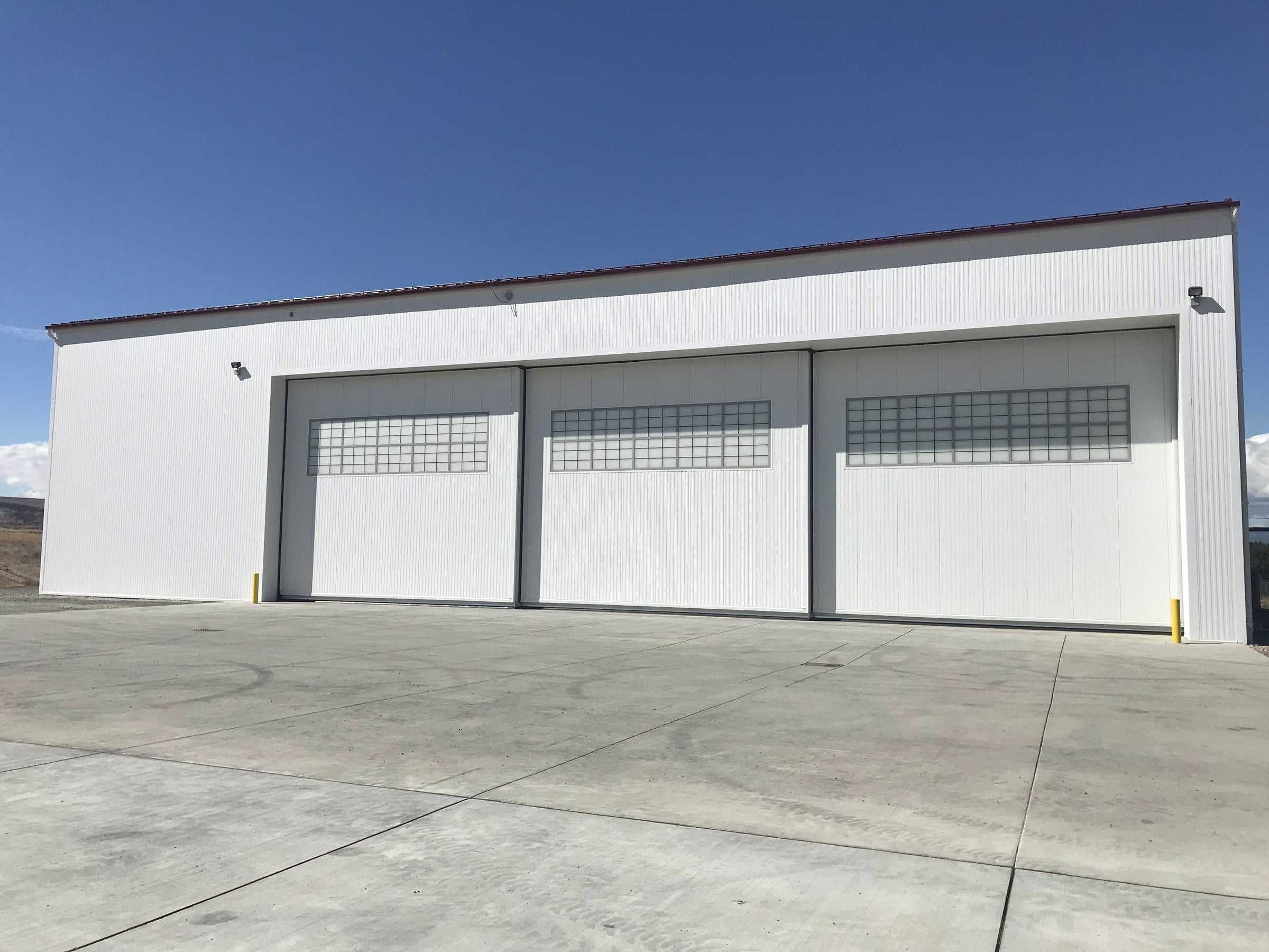 Medevac hangar at the Yakima Training Center, a large white metal building with three oversized doors built for a federal client