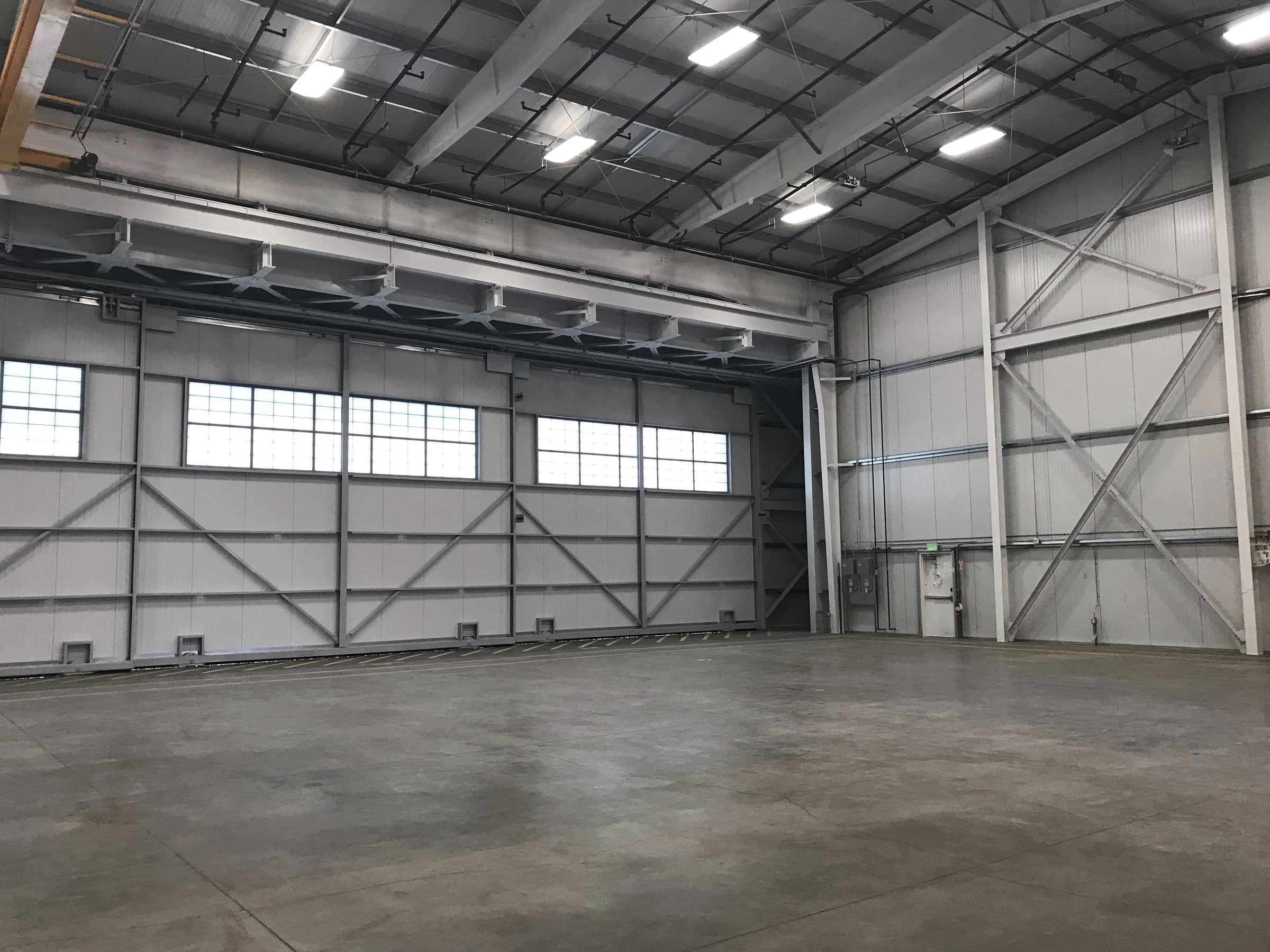 Interior of the Yakima Training Center medevac hangar with steel framing, high windows, and a concrete floor