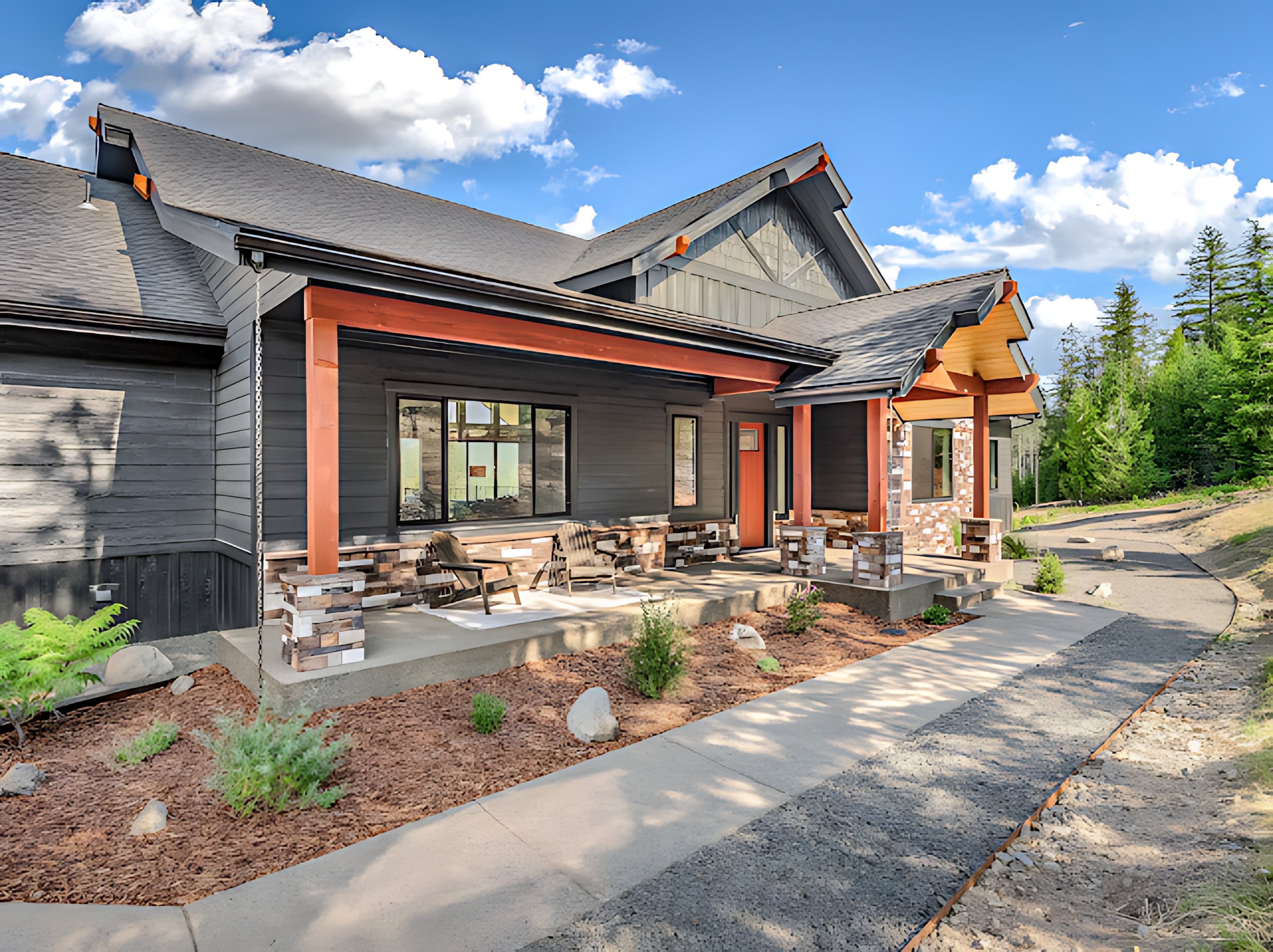ONYX-built custom home with a covered front porch, stacked stone columns, and a red front door