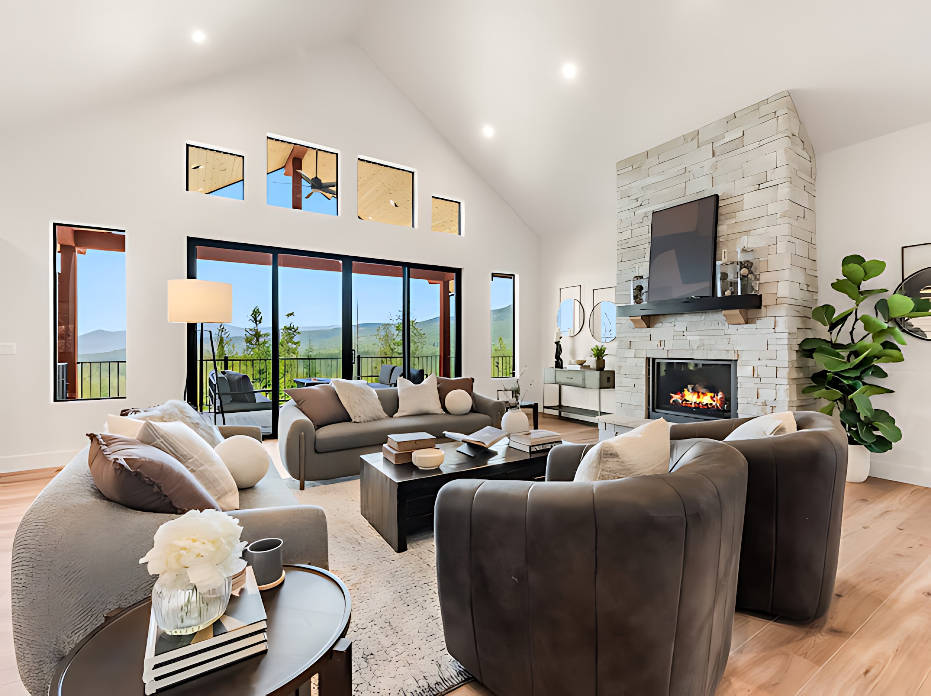 Vaulted living room with a floor-to-ceiling stacked stone fireplace